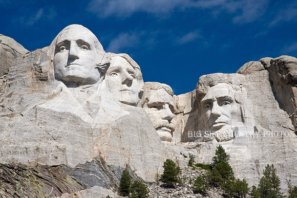 Mount Rushmore with a cobalt blue sky and thin whispy cirrus clouds