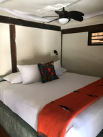Interior view of Zamas beachfront cabana - bed, mosquito net, fan